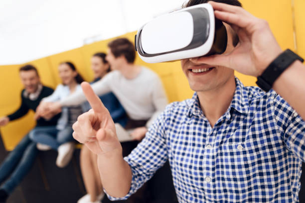 istock Happy intelligent man looks into virtual reality glasses. Creative team are working on project. 1290213763