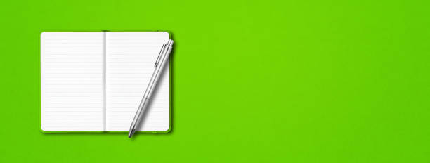 istock Green open notebook with a pen isolated on colorful background. Horizontal banner 1290214616