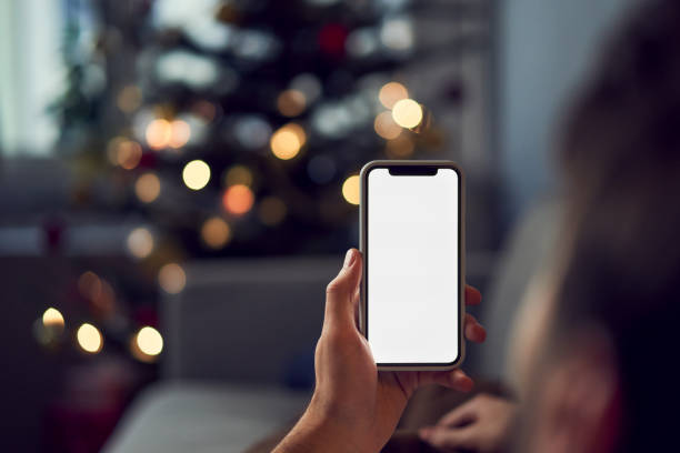 Man using smartphone during christmas at home stock photo