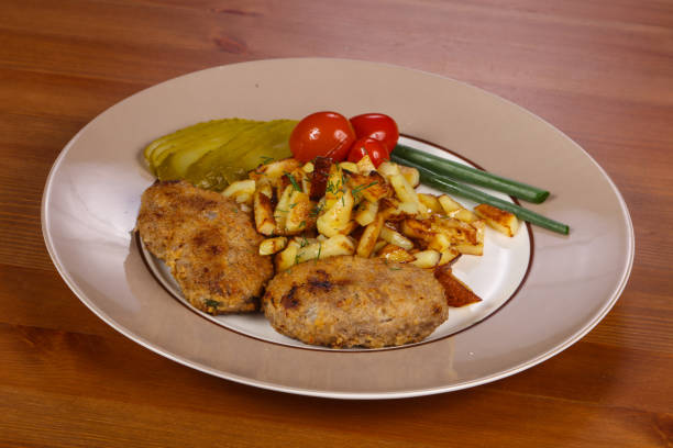 Homemade cutlet with roasted potato and pickled cucumber