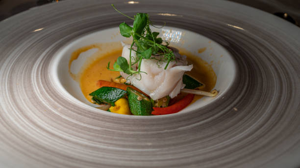istock Fish dish with vegetable and salads. Monkfish medallions. 1290225393