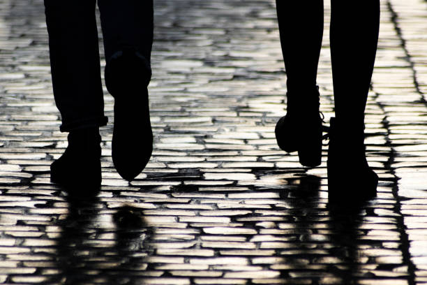 istock Two pedestrians walking down on evening street. 1290225638