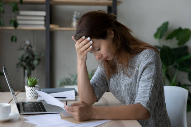 istock Depressed young woman stressed by getting bank debt notification. 1290230619