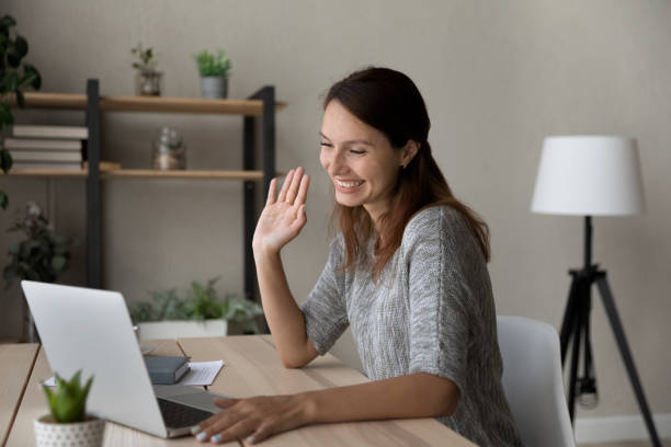 istock Beautiful woman making greeting gesture, starting video call. 1290230633