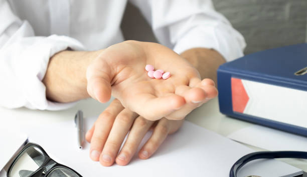 istock Pills, tablets and drugs pouring from bottle in doctor's hand on 1290230686
