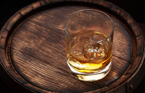 istock Scotch whiskey glass and old barrel 1290230773