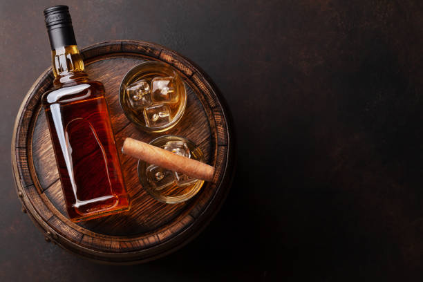 scotch whiskey bottle, glass, cigar and old barrel - cigar whisky bar cognac imagens e fotografias de stock