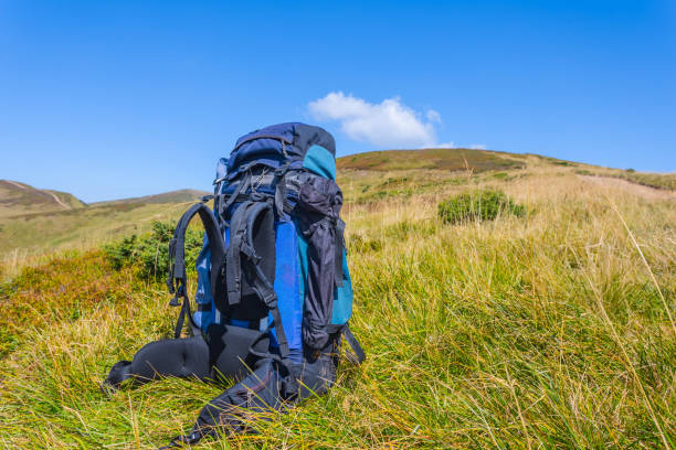 istock blue touristic backpack among a green mountains 1290232230