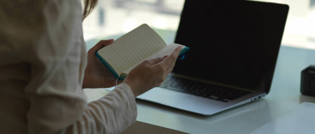 istock Businesswoman holding schedule book, check her schedule in workplace 1290233035