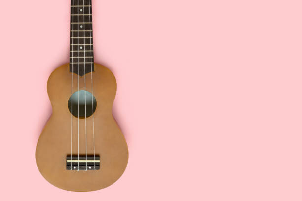 istock Flat lay of ukulele on a pastel pink background. 1290233263