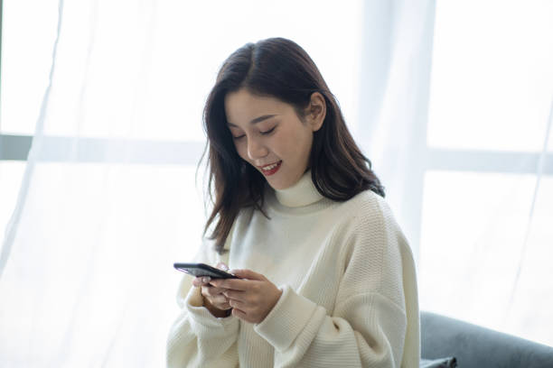 istock Young woman text messaging on mobile phone 1290233608