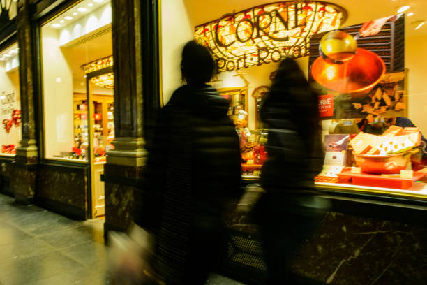 Two ladies walking past one of the many Belgian Chocolate shops in the city center of Brussels, the capital city of Belgium.