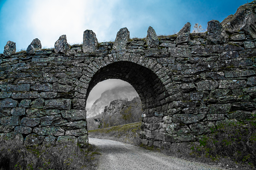 Old road bridge made from stone with an arch.