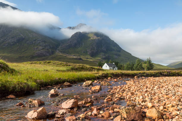 lagangarbh cottage, glencoe, scotland two hikers near distant bothy, summer, glencoe, scotland lochaber stock pictures, royalty-free photos & images