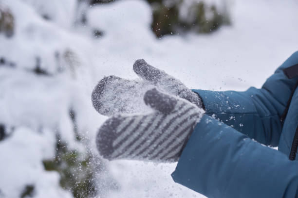 istock Woman in mittens claps hands in the snow. 1290238540