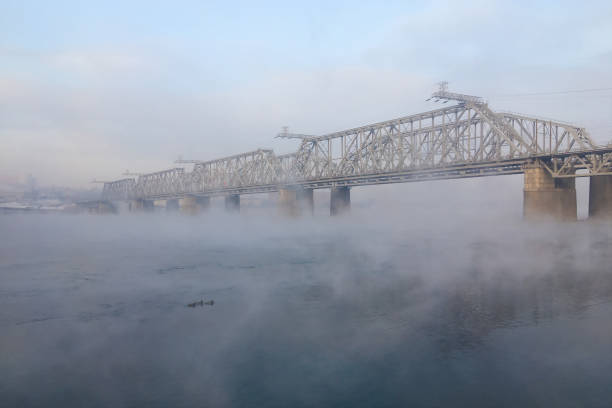 Bridge hidden in the fog Bridge in the fog. Winter morning on Yenisei river, Siberia krasnoyarsk photos stock pictures, royalty-free photos & images