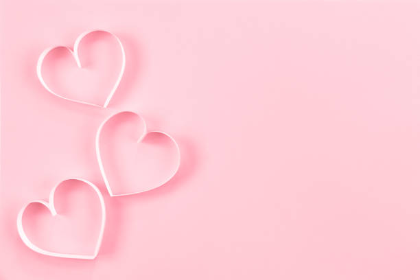 istock Paper cut hearts on pastel pink background. Composition for Valentine's Day, postcard. Flat lay, top view, copy space. 1290238878