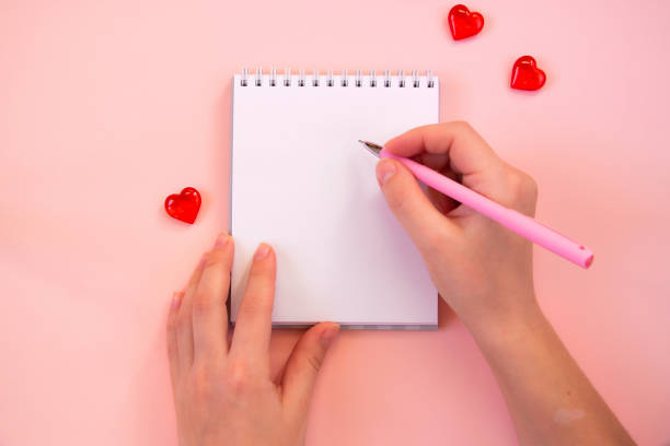 istock Paper cut hearts, notepad on pastel pink background. Composition for Valentine's Day, postcard. Flat lay, top view, copy space. 1290239056