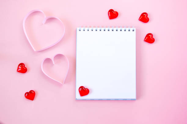 istock Paper cut hearts, notepad on pastel pink background. Composition for Valentine's Day, postcard. Flat lay, top view, copy space. 1290239060