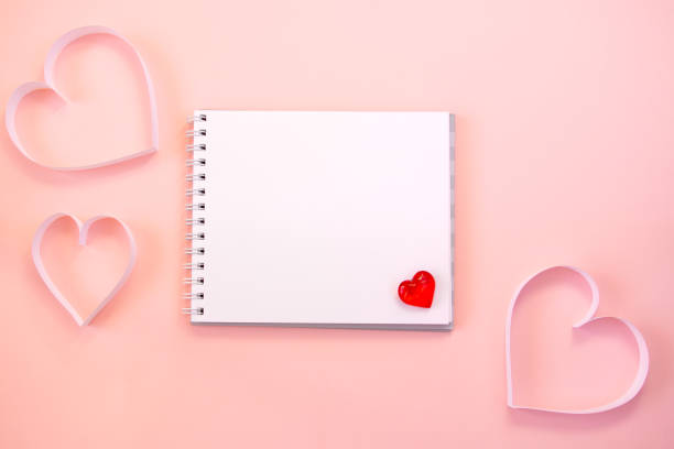 istock Paper cut hearts, notepad on pastel pink background. Composition for Valentine's Day, postcard. Flat lay, top view, copy space. 1290239100