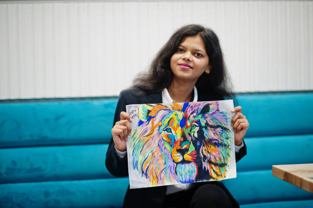 Indian artist woman wear formal paint picture, while sitting at cafe.
