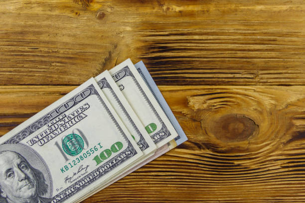 istock Stack of one hundred dollars bills on wooden desk 1290244907