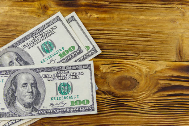 istock Stack of one hundred dollars bills on wooden desk 1290244911