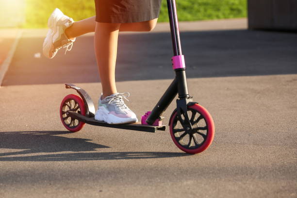 istock woman rides a scooter outdoors close-up. 1290249189
