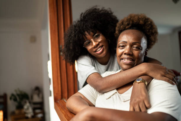Portrait of pride mother embracing teenager daughter at home Portrait of pride mother embracing teenager daughter at home grandma portrait stock pictures, royalty-free photos & images