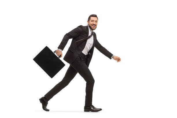 istock Businessman in a black suit running and looking at camera 1290251487