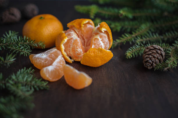 istock Tangerine on a wooden table, fir branches and cones. 1290251983