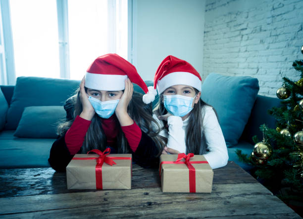 istock Sad and depressed children with mask at home bored at christmas feeling depressed missing family and friends. COVID-19 Lockdown, quarantine, stay home order, virtual christmas and mental health. 1290252142