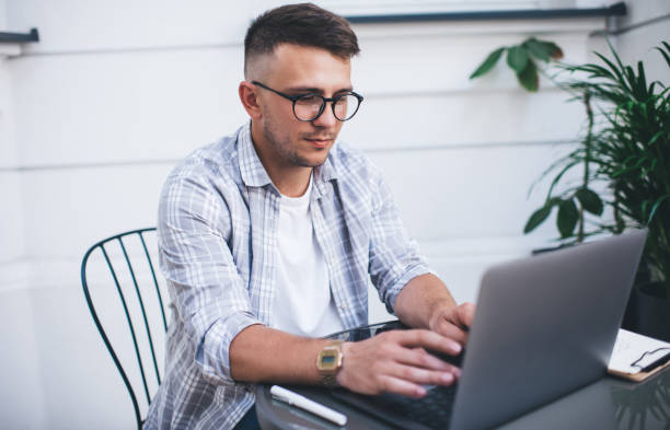 istock Serious man working on laptop on terrace 1290256920