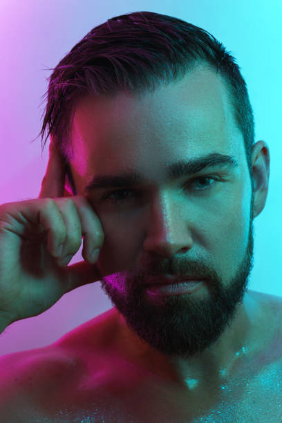 istock Handsome young man with wet skin in neon light 1290256990