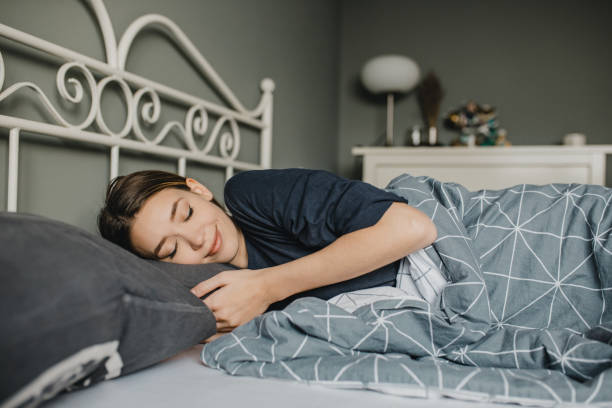 istock Young happy woman is sleeping in bed 1290257040
