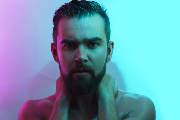 istock Handsome young man with wet skin in neon light 1290257049
