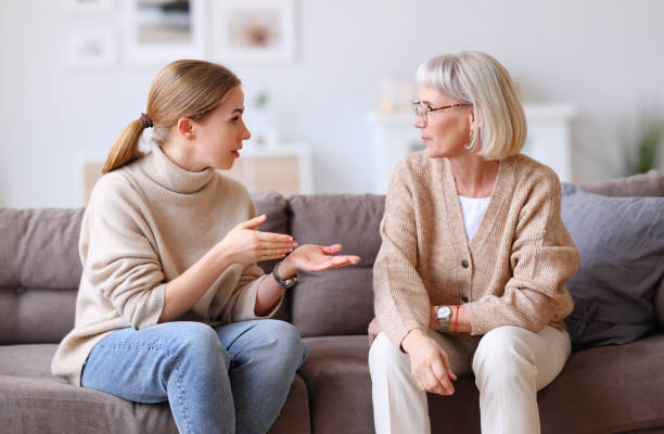istock Happy women chatting on sofa at home 1290257096