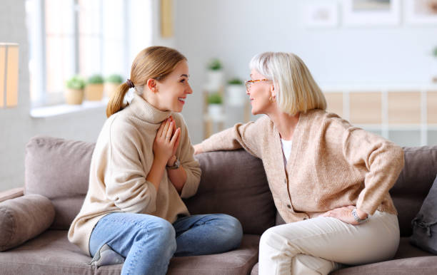 istock Happy women chatting on sofa at home 1290257111