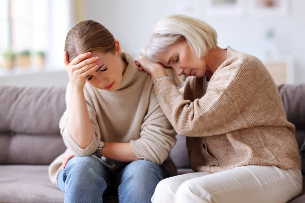 istock Mother comforting upset daughter on sofa 1290257181