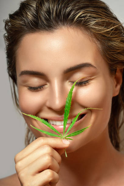 istock CBD cosmetics concept. Beautiful woman with a cannabis leaf 1290258584
