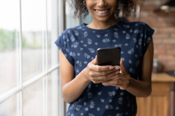 istock Close up happy multiracial young woman using mobile phone. 1290259725