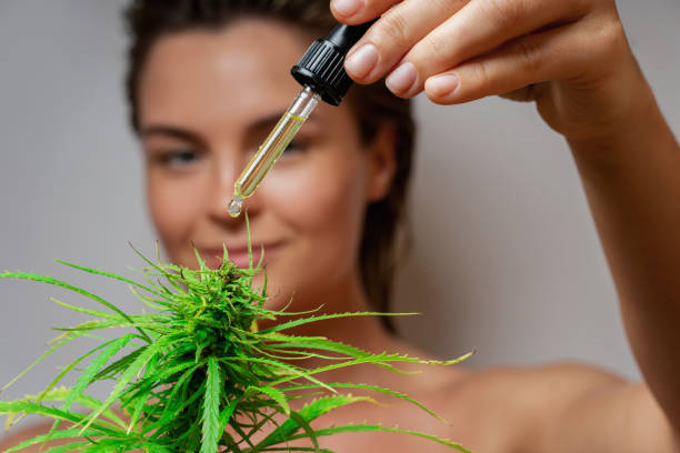 istock CBD cosmetics concept. Beautiful woman with a cannabis leaf 1290260000