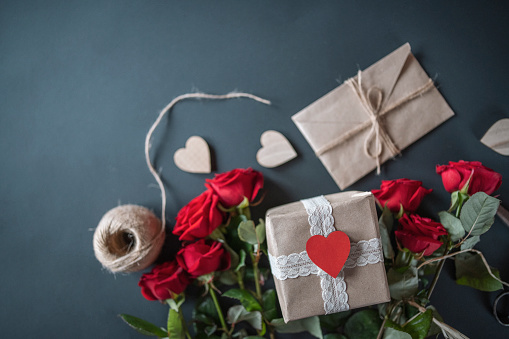 Close up of Valentine`s day background, bouquet of red roses and letter on clear background with copy space.