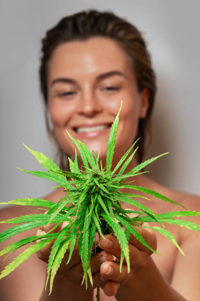 istock CBD cosmetics concept. Beautiful woman with a cannabis leaf 1290260152