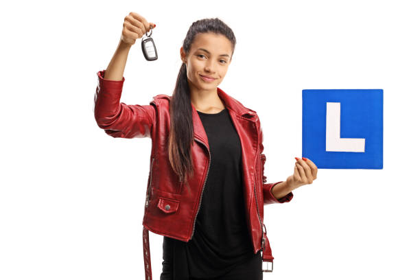 istock Female driver holding a car key and a learner plate 1290261435