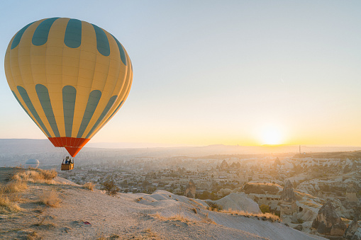 Women tourists holding man's hand and leading him to hot air balloons in Cappadocia, Turkey.