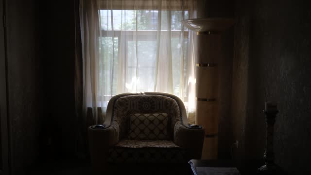 dark interior with vintage armchair on the background of a window with curtains