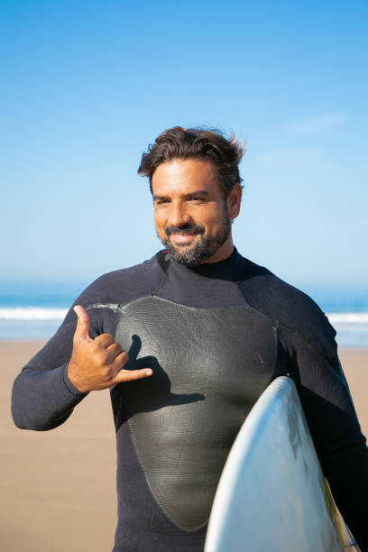 istock Cheerful bearded surfer standing with surfboard and smiling 1290263849