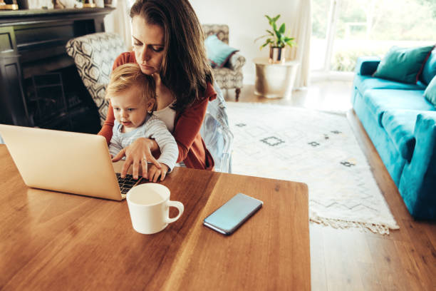 istock Working mother with her baby at home 1290264637