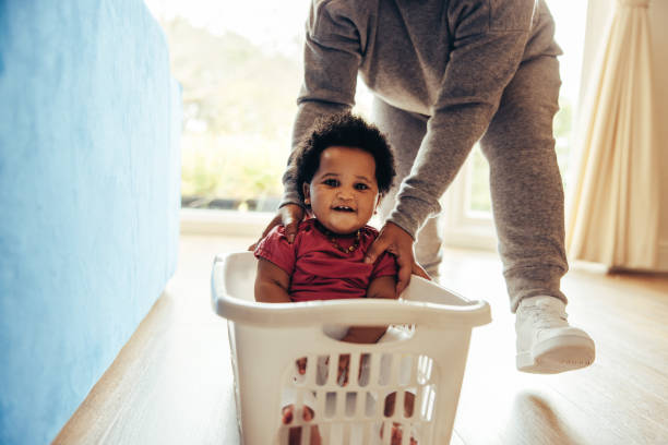 istock Happy child enjoying laundry basket ride at home 1290264966
